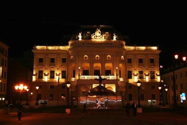 Slovak National Theatre illuminated at night in a dark Bratislava square
