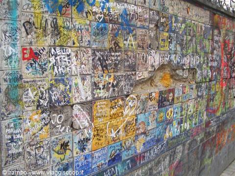 Wall of plastered bricks covered in colorful graffiti, the Lennon Wall
