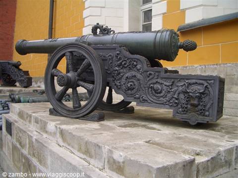 Old bronze cannon with ornate carved carriage displayed on stone base, Moscow Kremlin
