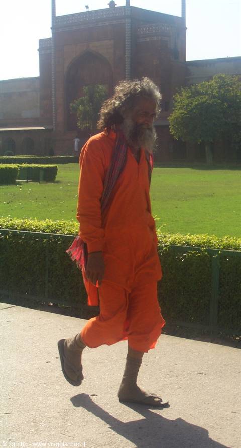 Sadhu in orange robe walking near the Taj Mahal gardens, Agra