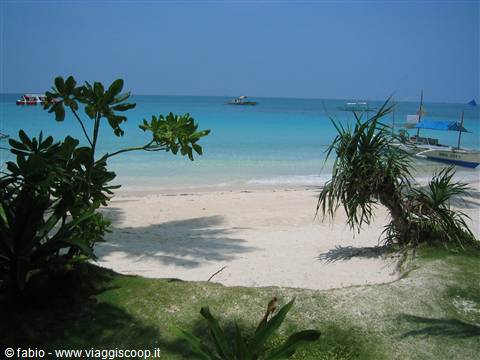 White sand beach with Filipino outrigger boats on turquoise sea, Boracay