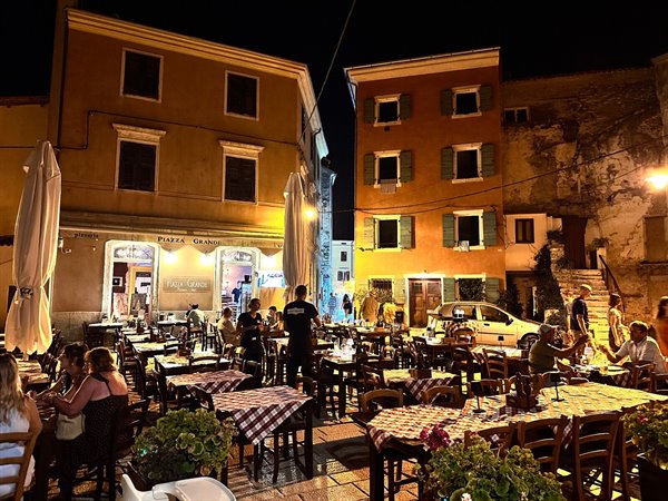 Dinner outdoors in Piazza Grande, IS Grove, under the warm evening lights