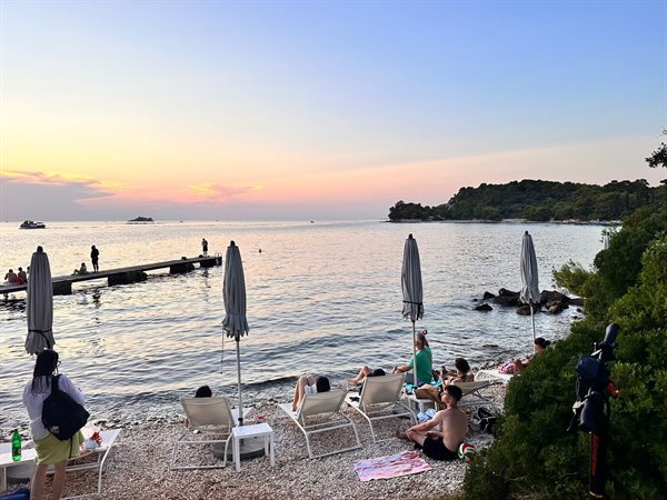 Golden sunset over the little beach of Ciolo, relaxation and a calm sea.