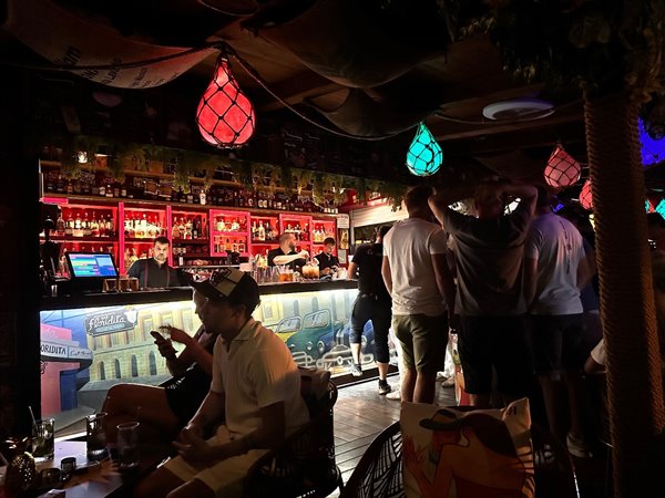 Evening at Floridita: colourful lights, cocktails and laughter at the bar.