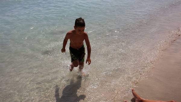 Playing in the crystal-clear water, laughter and sunshine at the sea.