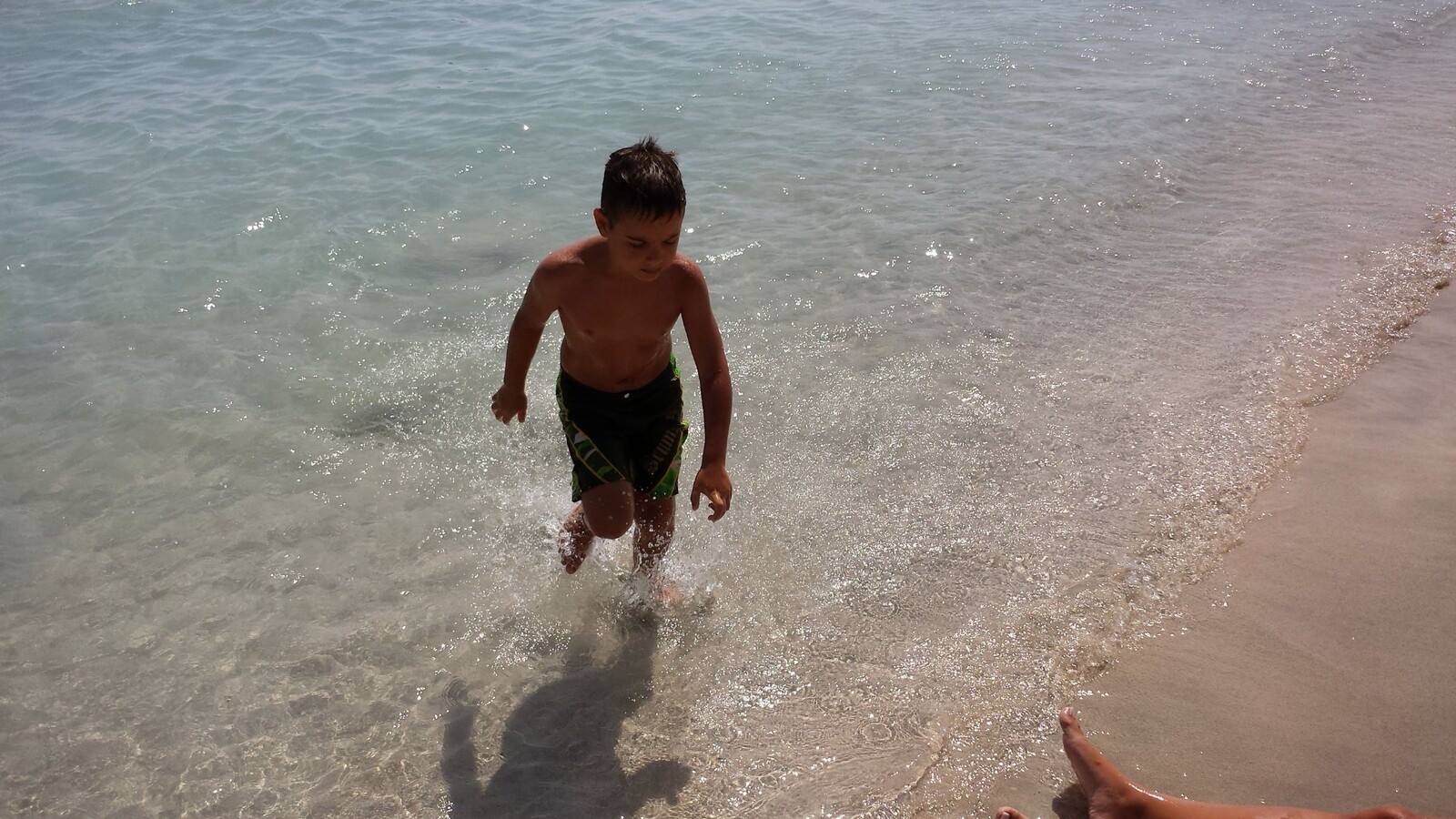 Giocando nell'acqua cristallina, risate e sole al mare.