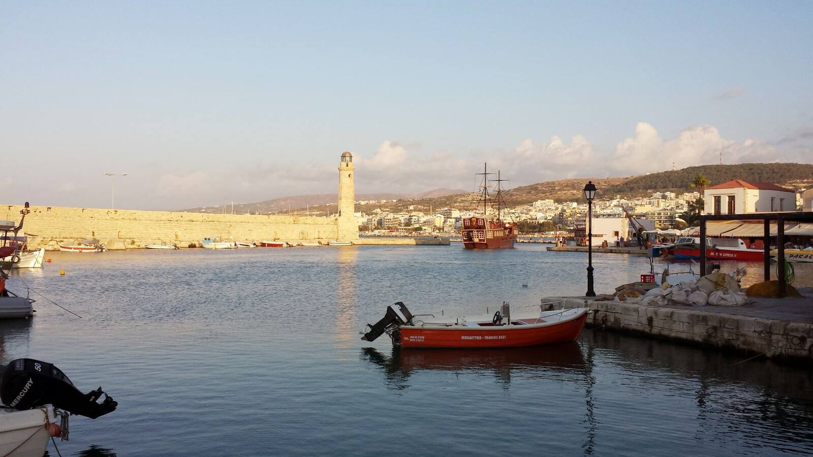 Il faro veneziano di Retimo al tramonto: il porto tace, tutto è dorato.