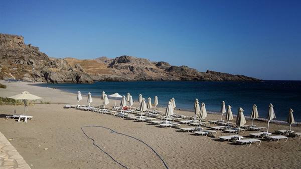 The bay of Lindos in the morning, closed umbrellas waiting for lazy mornings.