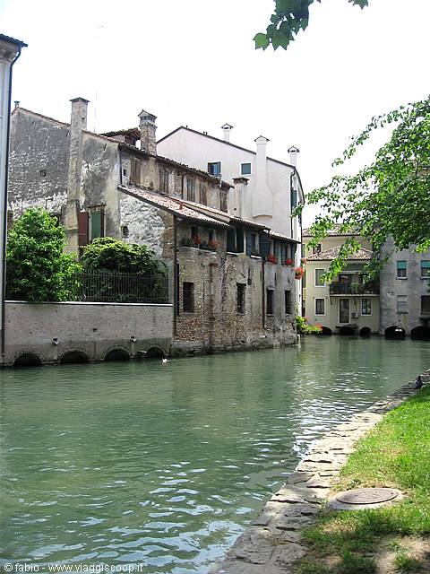 Old brick and peeling plaster houses along the Buranelli canal in Treviso