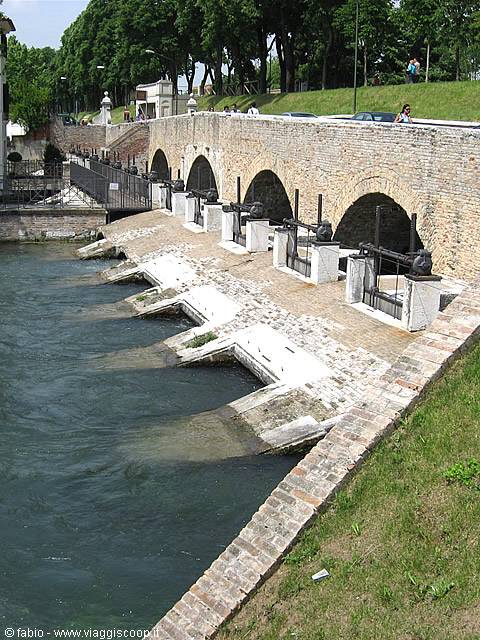 Trepponti bridge in Comacchio, brick arches and stone sluices over green water