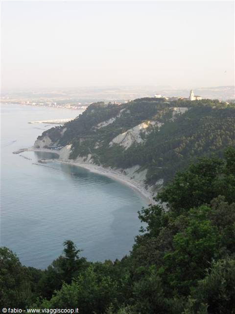 Pebble beach cove beneath the green cliffs of Monte Conero