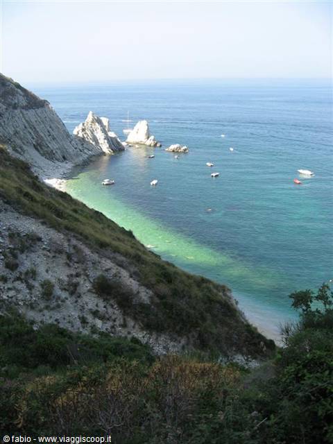 Due Sorelle beach at Conero, white sea stacks and boats on turquoise water