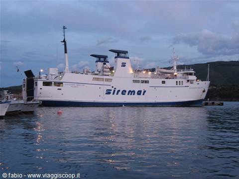Siremar ferry moored at dusk, lights glowing over calm water