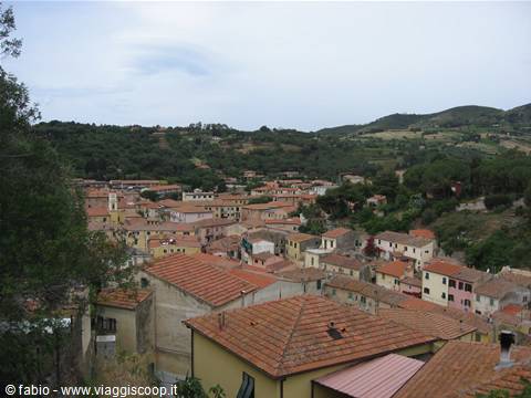 Terracotta rooftops of a village surrounded by green hills