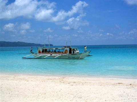 Traditional Filipino outrigger boat moored in turquoise water at Boracay, white sand beach