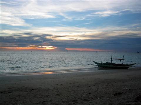Wooden fishing boat moored on the beach under early morning sky