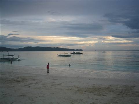 Traditional Filipino boats moored on Boracay beach at dusk