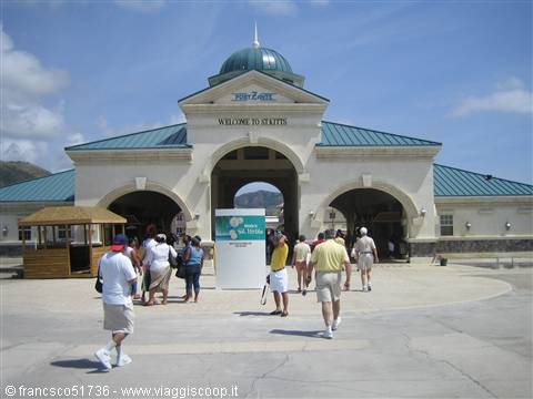 Tourists walk in front of St. Kitts port entrance with green dome