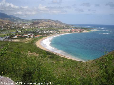 Golden sand beach and turquoise water at Frigate Bay, Saint Kitts, green hills