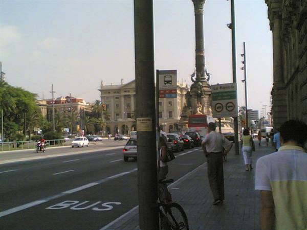 Pedestrians and traffic along the Rambla, ornate lamppost between poles