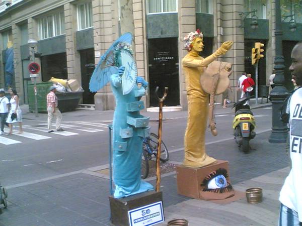 Golden and turquoise living statues with umbrella on La Rambla, Barcelona