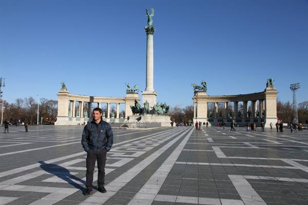 Tourist in blue jacket in front of the Millennium Column at Heroes' Square