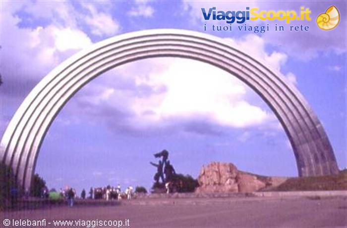 The steel Friendship Arch in Kyiv with the statue in front