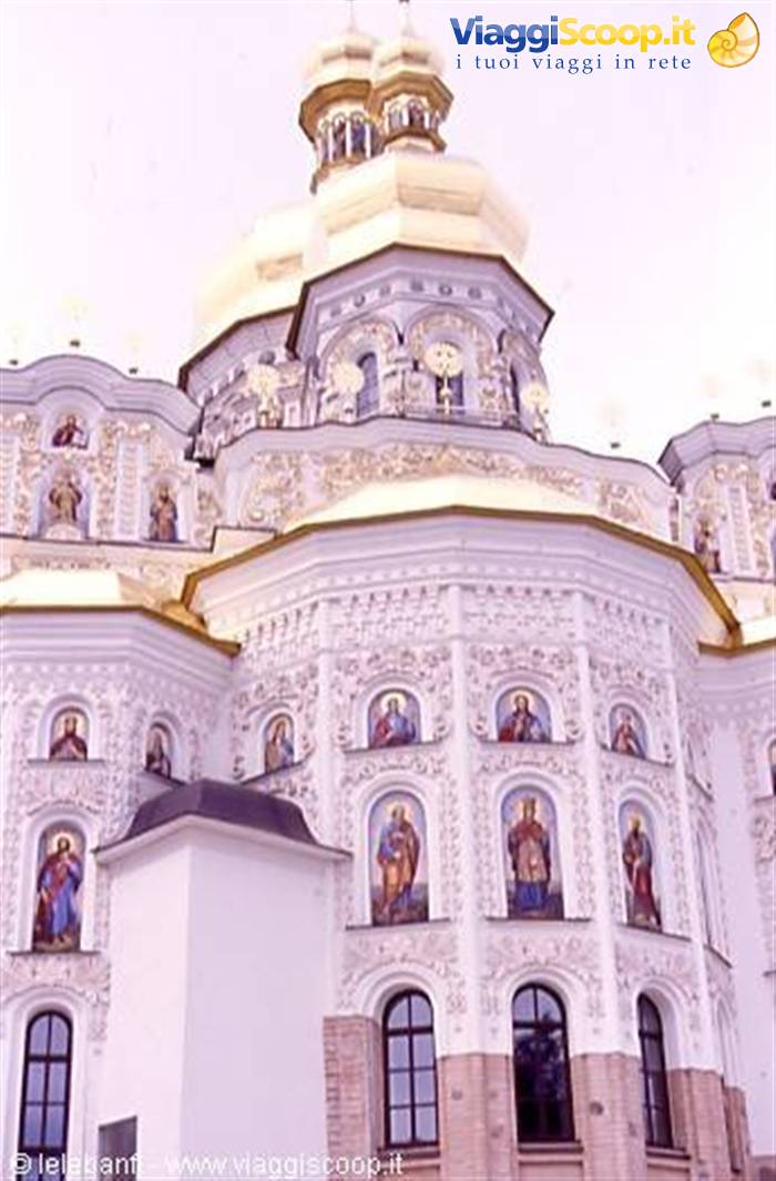 White facade of Kyiv Pechersk Lavra cathedral, golden domes and mosaics