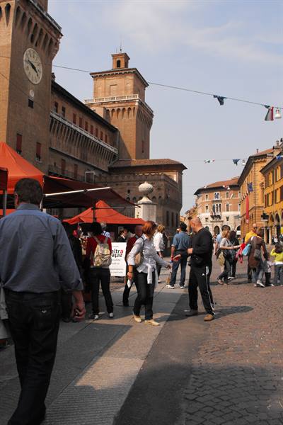 Visitors strolling in the square in front of Ferrara's Estense Castle