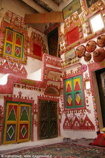 Painted interior in Ghadames: red walls, green doorways, silver vessels on display