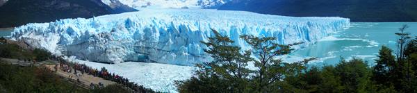 Tourists on wooden walkways in front of Perito Moreno glacier
