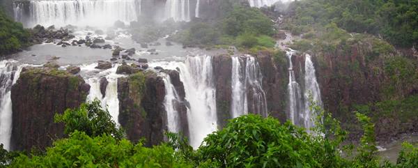 Iguazú Falls: basalt cliffs, white water cascades amid lush green vegetation