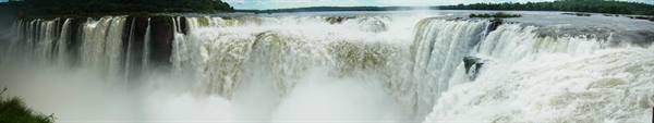 Iguazú Falls, powerful white water plunging over rocks amid green forest