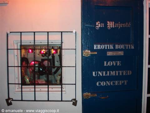 Blue Erotik Boutique door with barred window glowing red light inside
