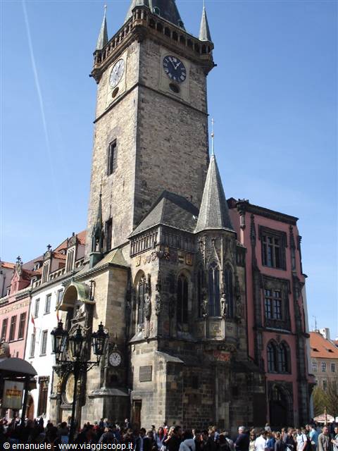 Astronomical Clock tower in Prague, crowd of tourists under blue sky