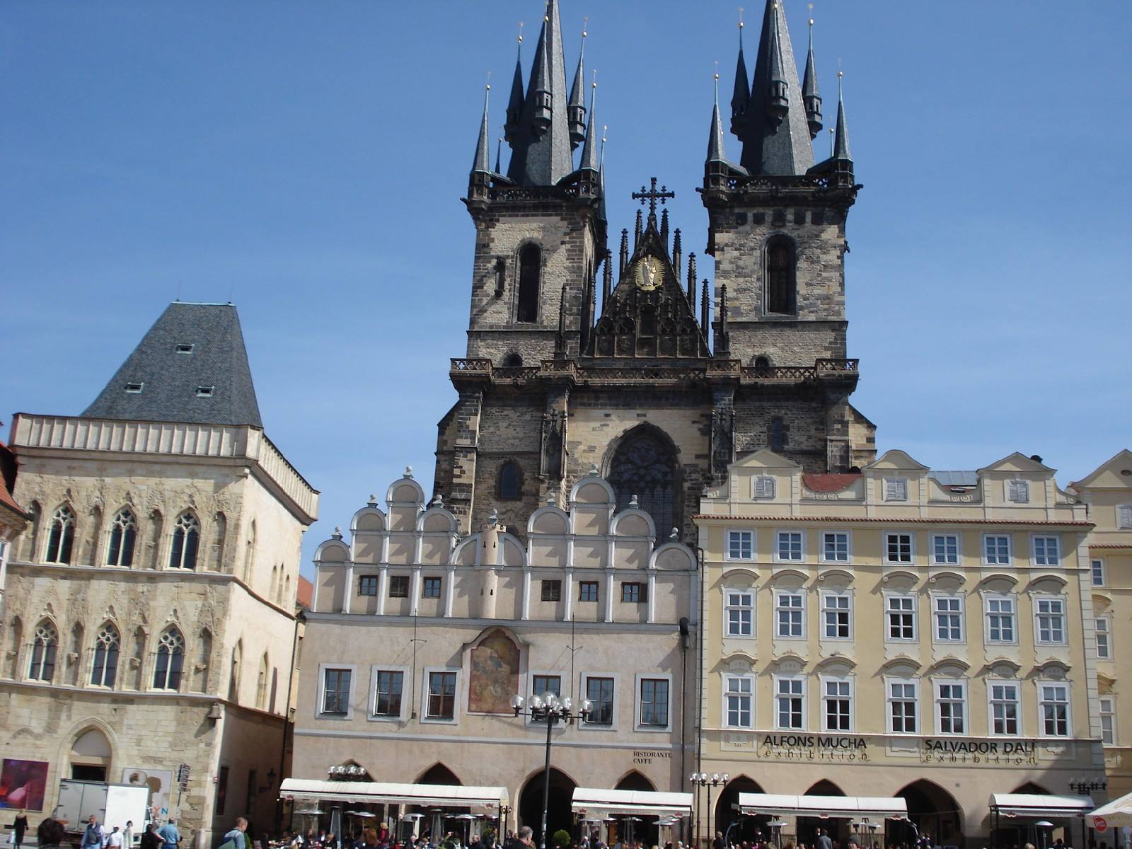 Tourists beneath the Gothic spires of Týn Church in Prague