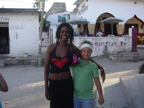 Smiling woman and blond boy pose in front of a local restaurant