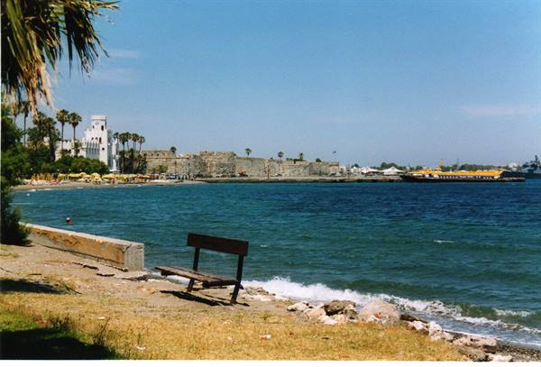 Wooden bench by the shore facing Kos castle and harbor