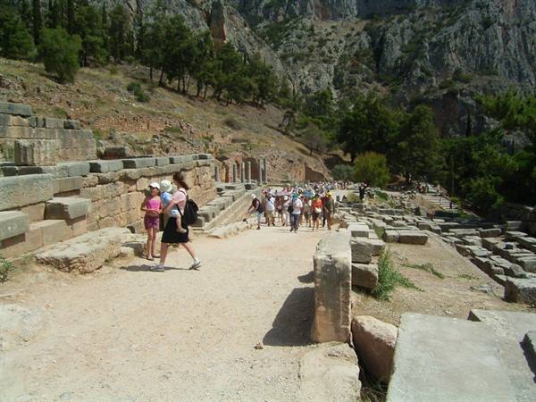 Tourists walking the stone sacred way at the Delphi archaeological site