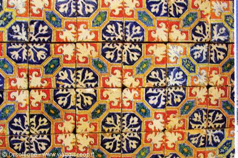 Glazed ceramic tiles painted with blue and orange floral patterns