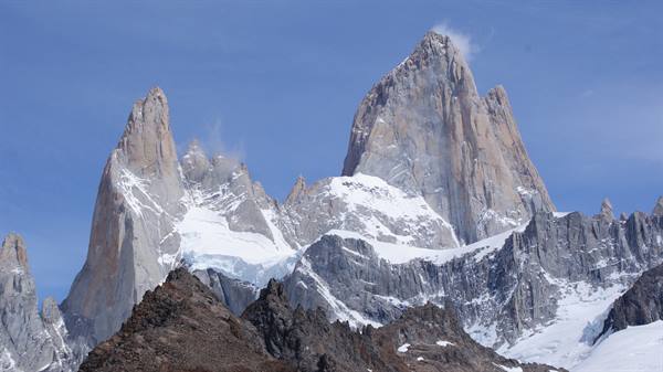 Snowy granite spires of Mount Fitz Roy against a blue sky, El Chaltén