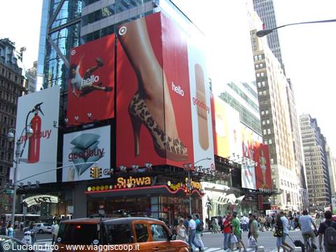 Red Target billboards on glass building in Times Square, yellow taxis and crowd
