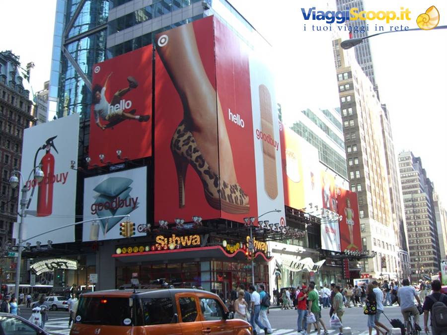 Red Target billboards on glass building in Times Square, yellow taxis and crowd