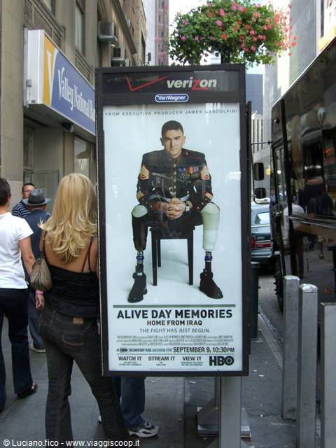 Blonde woman looking at HBO poster of wounded marine on a New York street