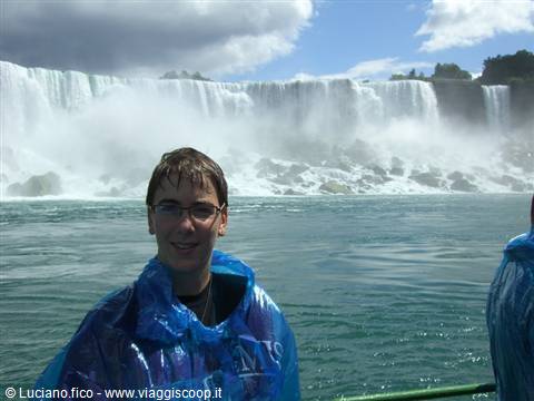Boy in blue poncho in front of Niagara Falls