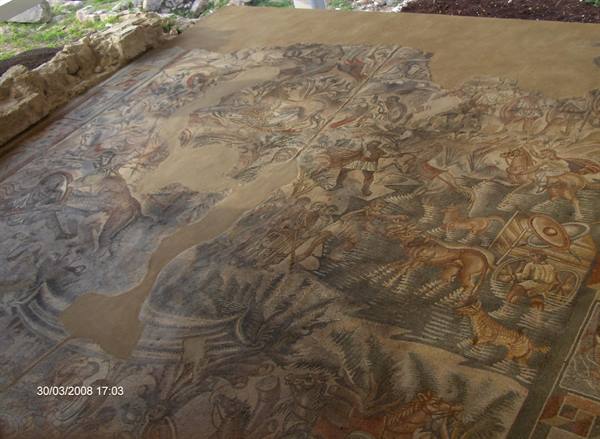Roman mosaic floor depicting a hunt with horses, weathered stone tesserae