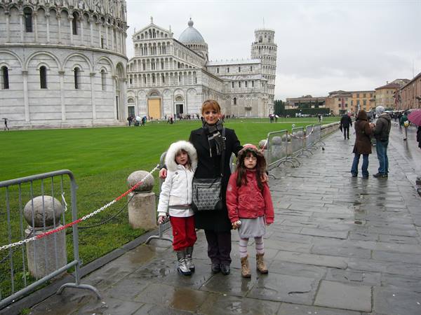 Mother and two girls in front of Pisa Cathedral and the leaning tower