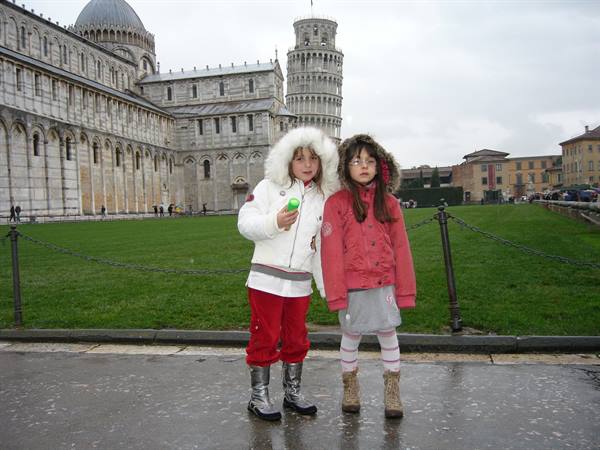 Two girls in front of the Leaning Tower and cathedral of Pisa
