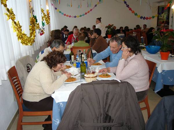 Diners at decorated trattoria with garlands and paper stars in Viareggio