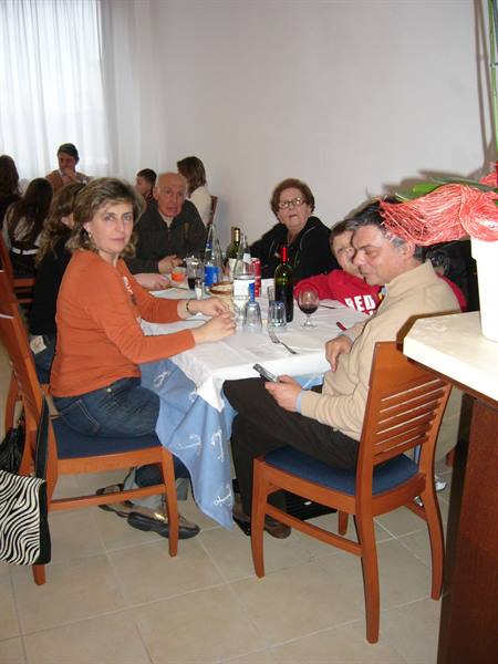 People sitting at a set table with wine and drinks in a dining hall